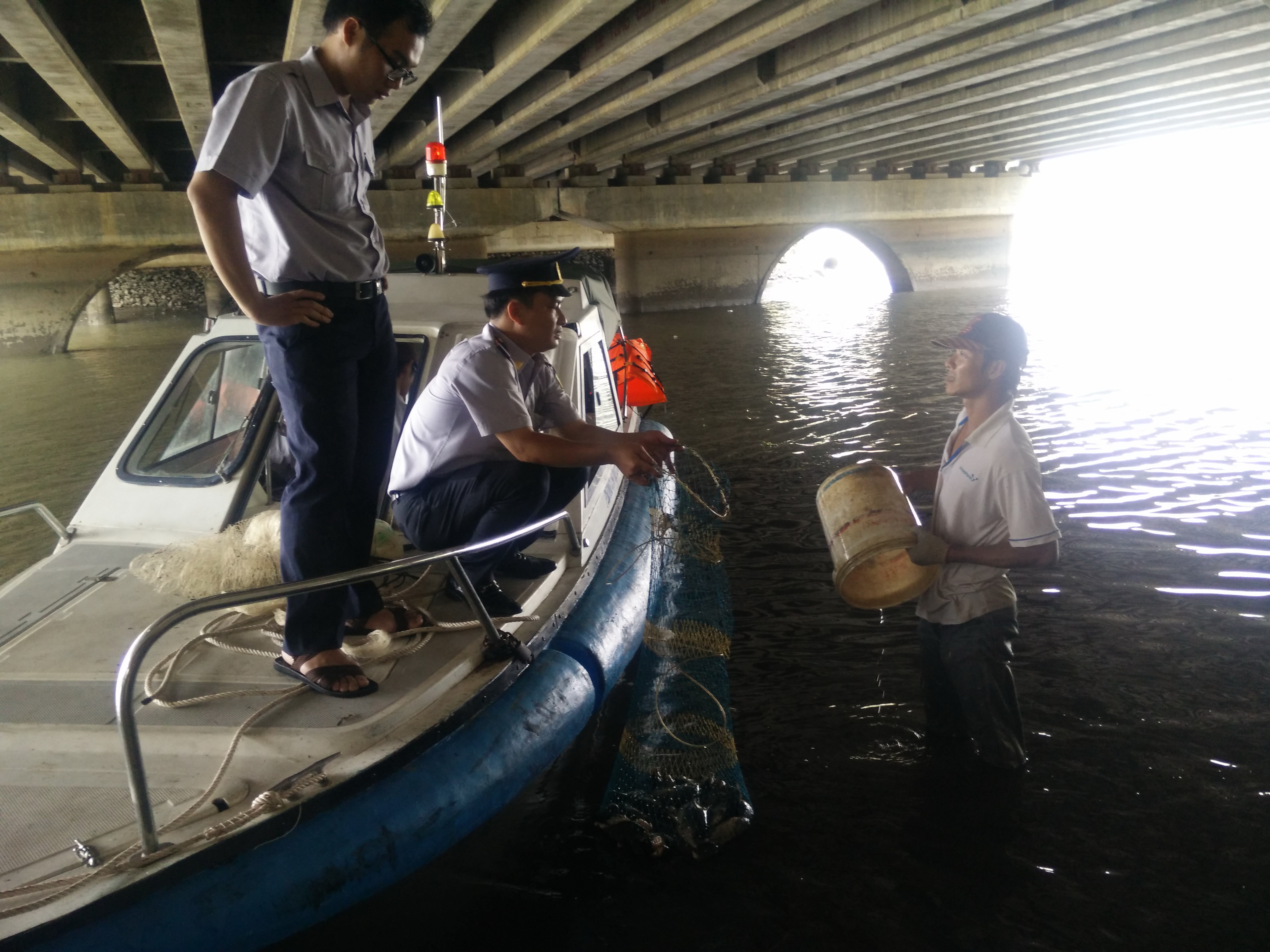 Đoàn kiểm tra phát hiện Lê Văn Giang đang chài lưới dưới chân cầu Thị Nghè 2 - Ảnh: Công Nguyên
