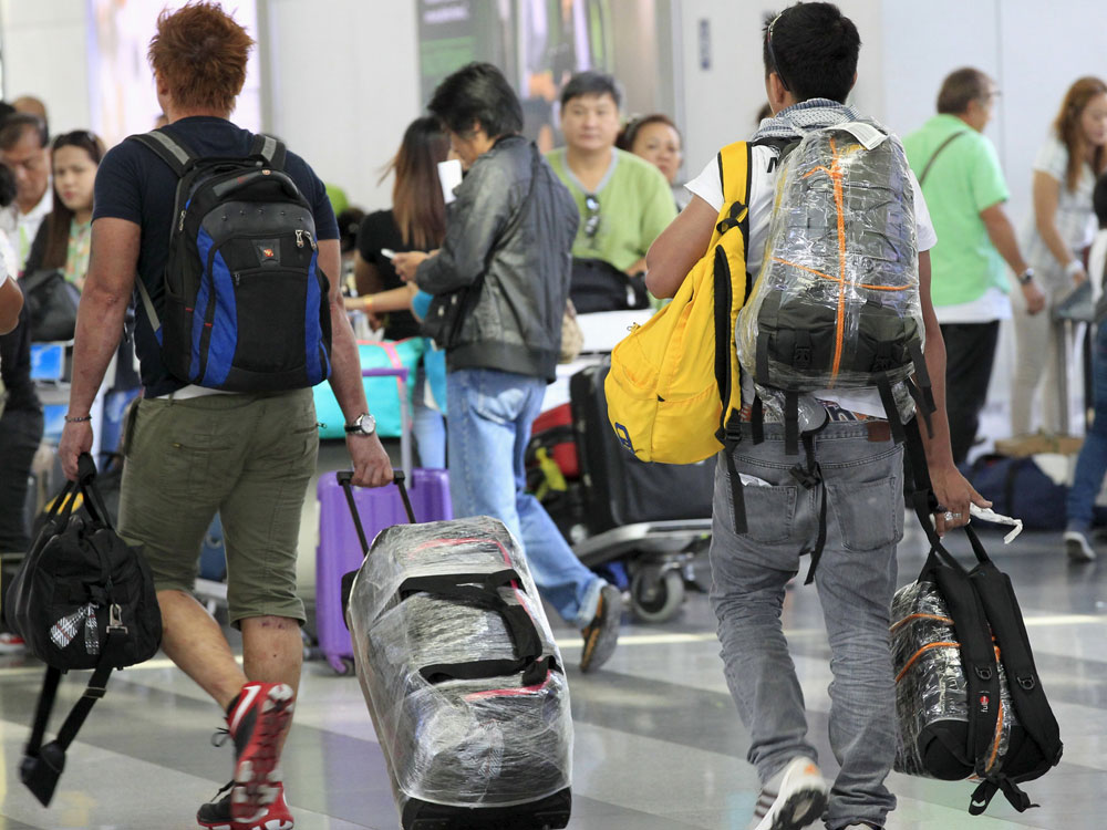 Nhiều hành khách tại sân bay Ninoy Aquino bao bọc kỹ hành lý để tránh bị gài đạn - Ảnh: Reuters