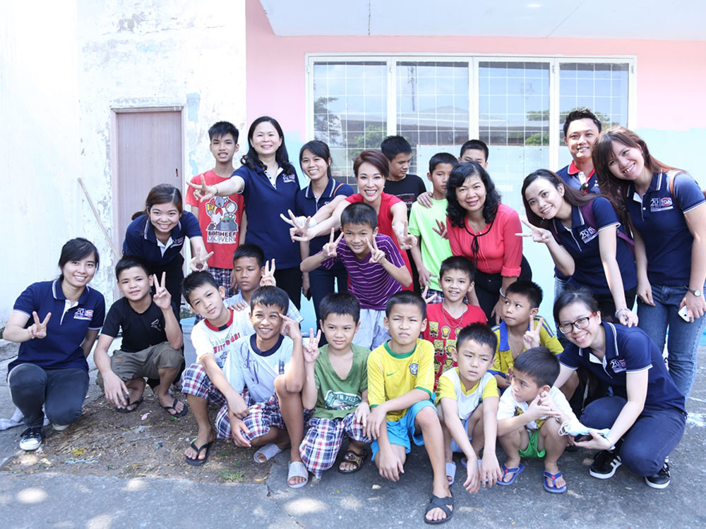 Uyên Linh cùng nhóm fan và các tình nguyện viên chụp ảnh lưu niệm với các em nhỏ của Trung tâm Giáo dục dạy nghề Thiếu niên TP.HCM