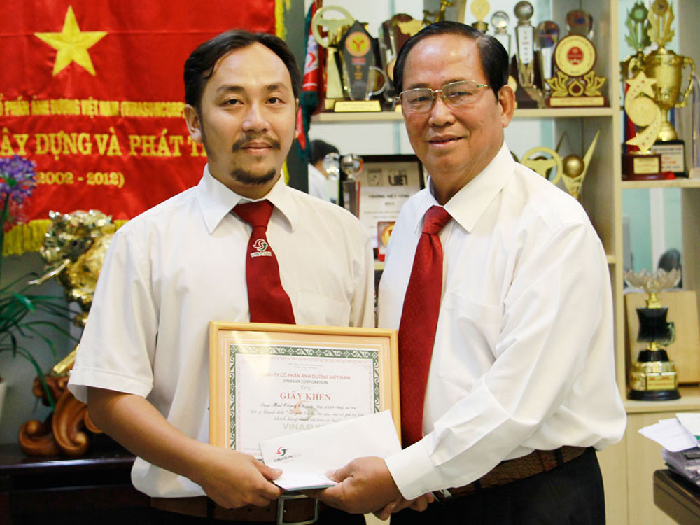 Ông Tạ Long Hỷ, Giám đốc taxi Vinasun, trao giấy khen cho lái xe Mai Công Chính (trái) - Ảnh: Ngọc Quỳnh
