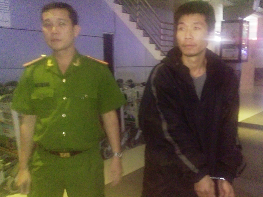 Xue Wen bị áp giải từ sân bay Tân Sơn Nhất về cơ quan công an - Ảnh: Nguyên Bảo