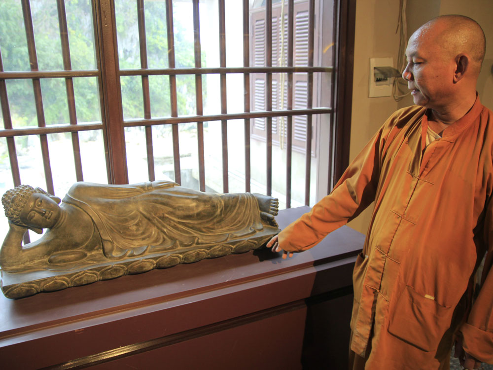 Thượng tọa Thích Huệ Vinh bên cạnh pho tượng Phật quý giá - Ảnh: Hoàng Sơn