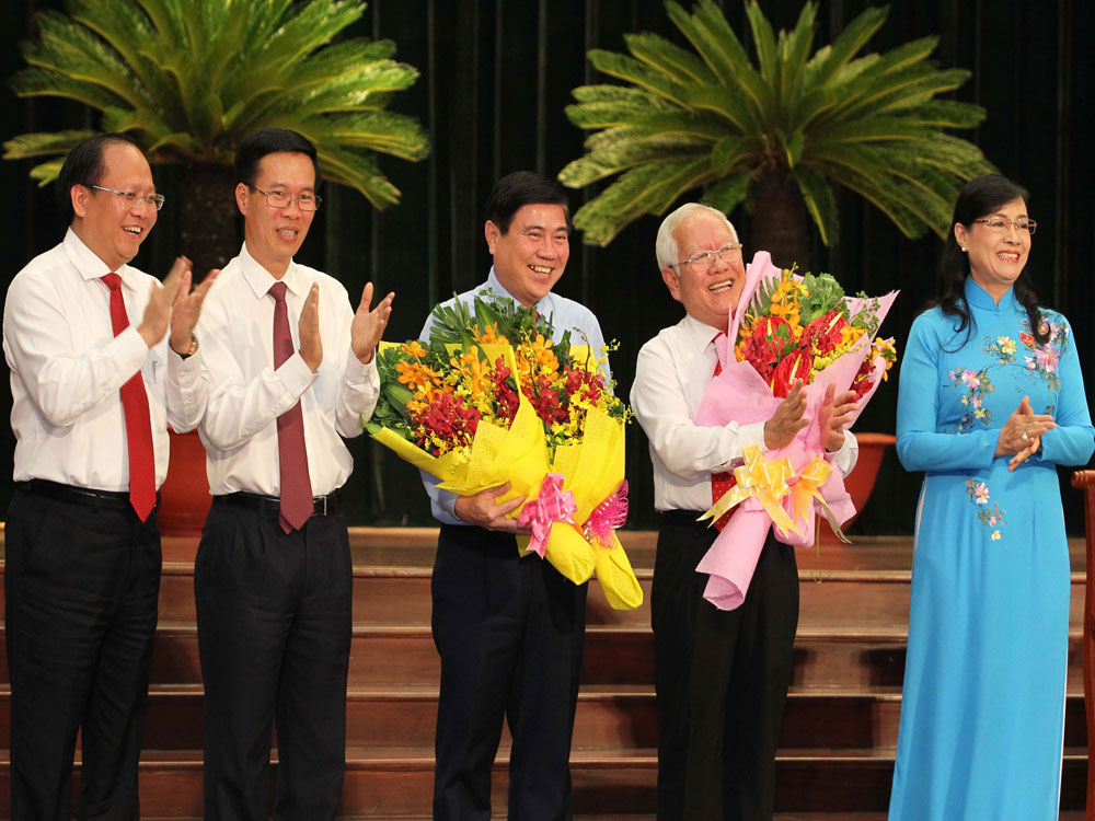 Lãnh đạo Thành ủy tặng hoa ông Nguyễn Thành Phong và nguyên Chủ tịch UBND TP.HCM Lê Hoàng Quân - Ảnh: Diệp Đức Minh