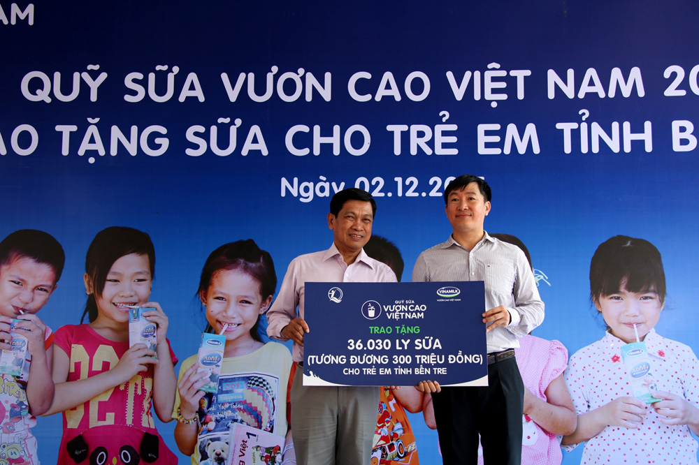 Ông Đỗ Thanh Tuấn, Trưởng bộ phận Đối ngoại Vinamilk trao tặng bảng tượng trưng 36.030 ly sữa tương đương 300 triệu đồng cho đại diện Quỹ Bảo trợ trẻ em tỉnh Bến Tre