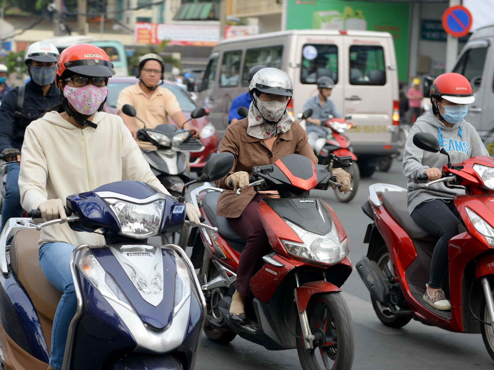Nhiều người dân Sài Gòn phải khoác áo ấm khi ra đường - Ảnh: Diệp Đức Minh