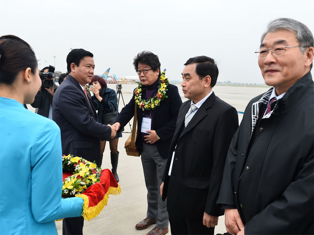 Bộ trưởng Bộ Giao thông vận tải Đinh La Thăng tặng hoa cho hành khách trên chuyến bay từ Incheon (Hàn Quốc) về Hà Nội - Ảnh: VNA