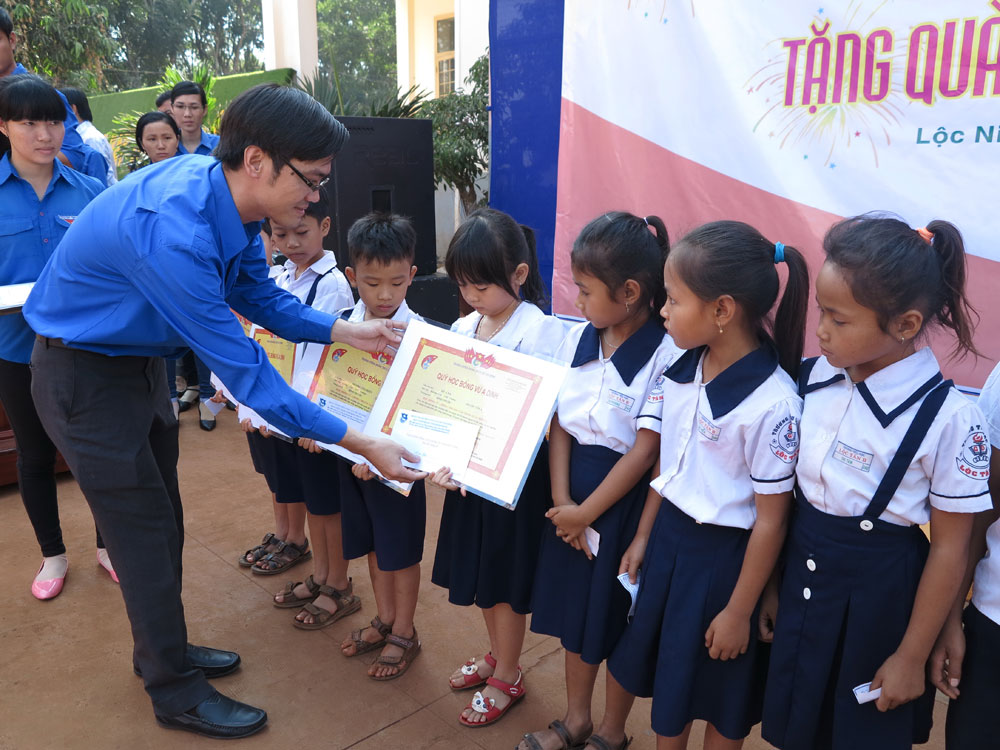 Anh Đào Quang Dũng, Bí thư Đoàn cơ sở phía Nam (Cơ quan T.Ư Đoàn) trao học bổng cho con em đồng bào dân tộc ít người tại huyện Lộc Ninh - Ảnh: Lê Thanh