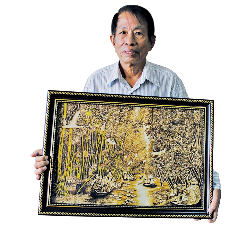 Ông Tạng với tấm tranh trấu chủ đề rừng tràm ở An Giang - Ảnh: Thanh Dũng