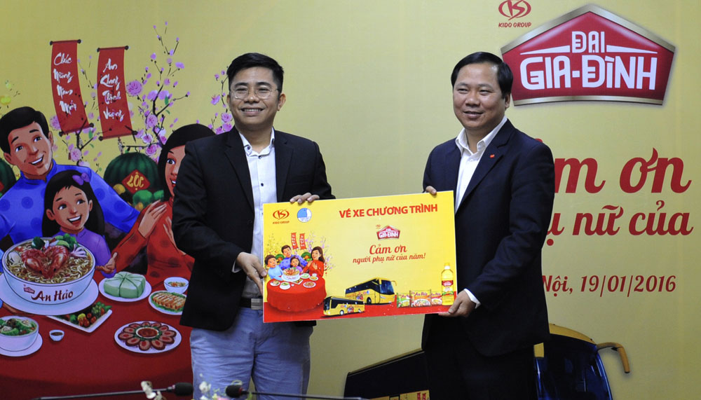 Anh Nguyễn Phi Long (bên phải) nhận vé tượng trưng từ đại diện Tập đoàn KIDO tài trợ trong chương trình - Ảnh: Hoàng Lý