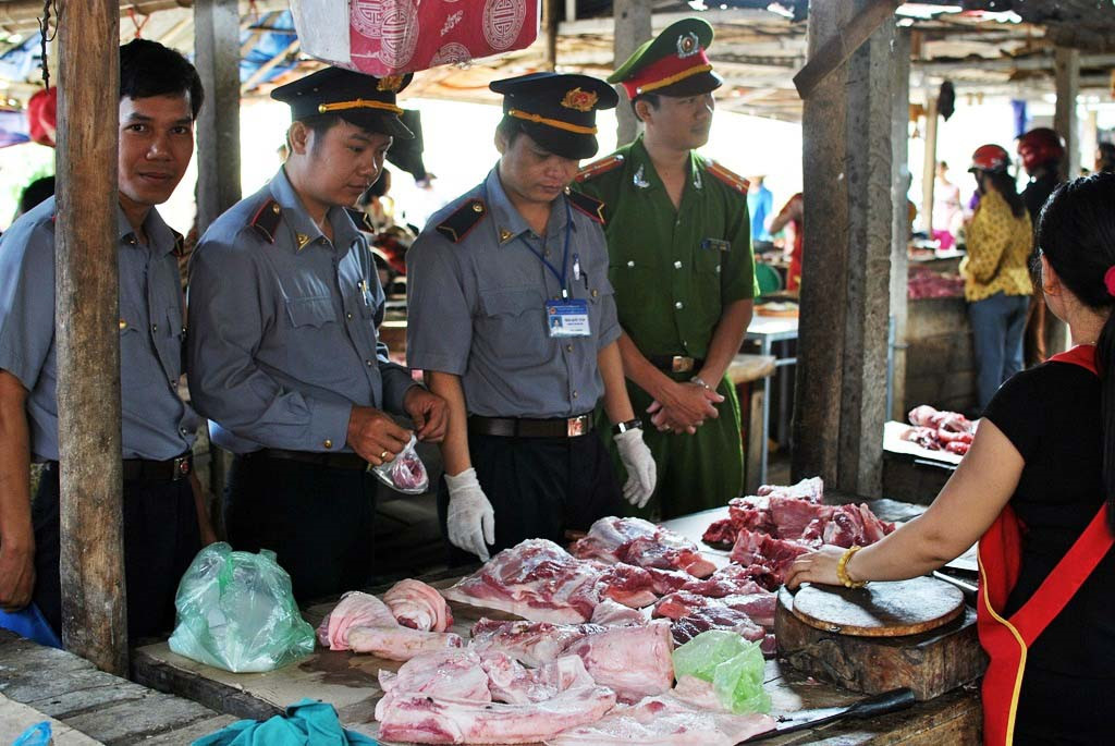 Một đoàn thanh tra đang kiểm tra thực phẩm bán tại chợ