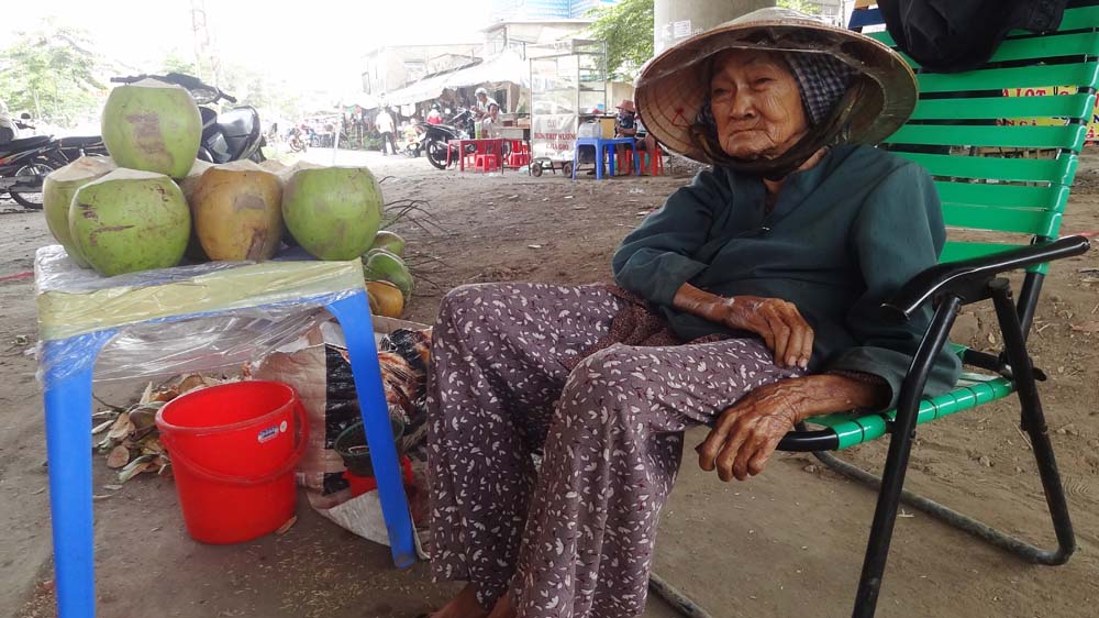 Hằng ngày bà Bảy ra gầm cầu Bình Lợi ngồi ngóng khách mua dừa để kiếm tiền lo cuộc sống