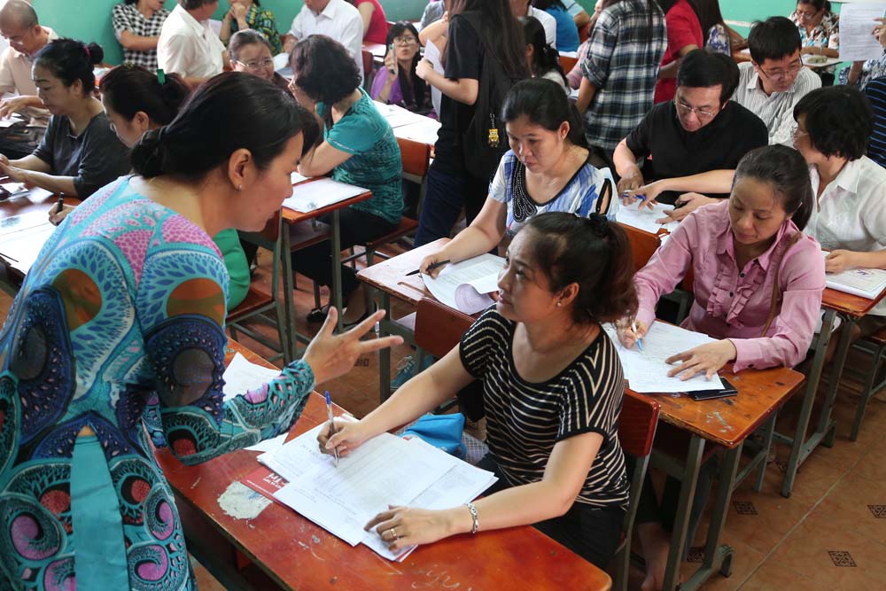 Giáo viên Trường THCS Võ Trường Toản (Q.1, TP.HCM) hướng dẫn phụ huynh đăng ký nguyện vọng vào lớp 10 cho học sinh - Ảnh: Đào Ngọc Thạch