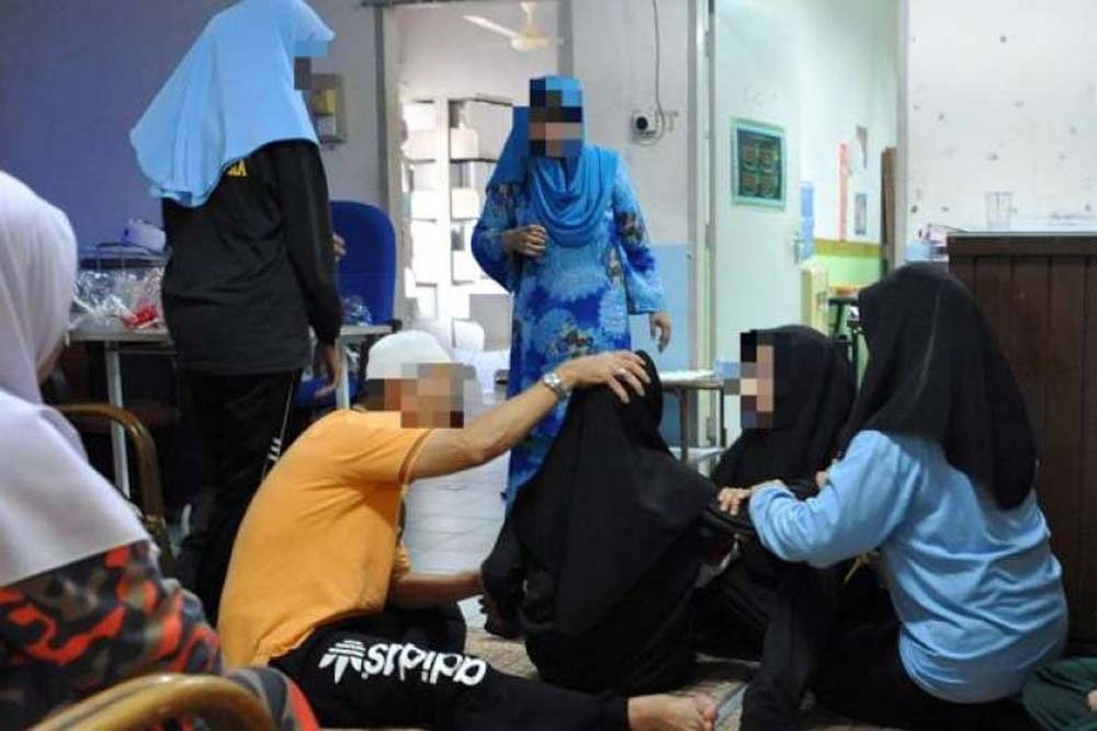 Giáo viên đang chăm sóc cho một học sinh mắc bệnh ở Kota Baru - Ảnh: The Star
