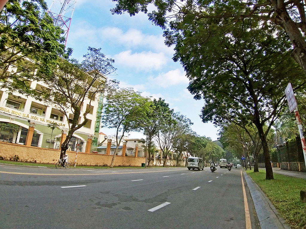 Buổi sáng đẹp trời, ít xe cộ qua lại có lẽ là khoảnh khắc mà người Sài Gòn yêu thích nhất. Có thể thấy rằng phần tiếp giáp của tòa nhà trường đại học, các tán cây với bầu trời xanh được xử lý mượt mà