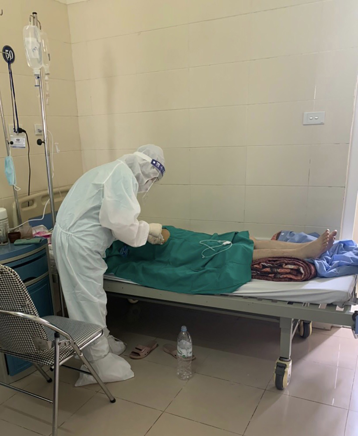 Trong bộ quần áo bảo hộ nóng bức, ngột ngạt, bác sĩ Hương Giang vẫn cần mần khám, chăm sóc bệnh nhân ung thu đang cách ly
