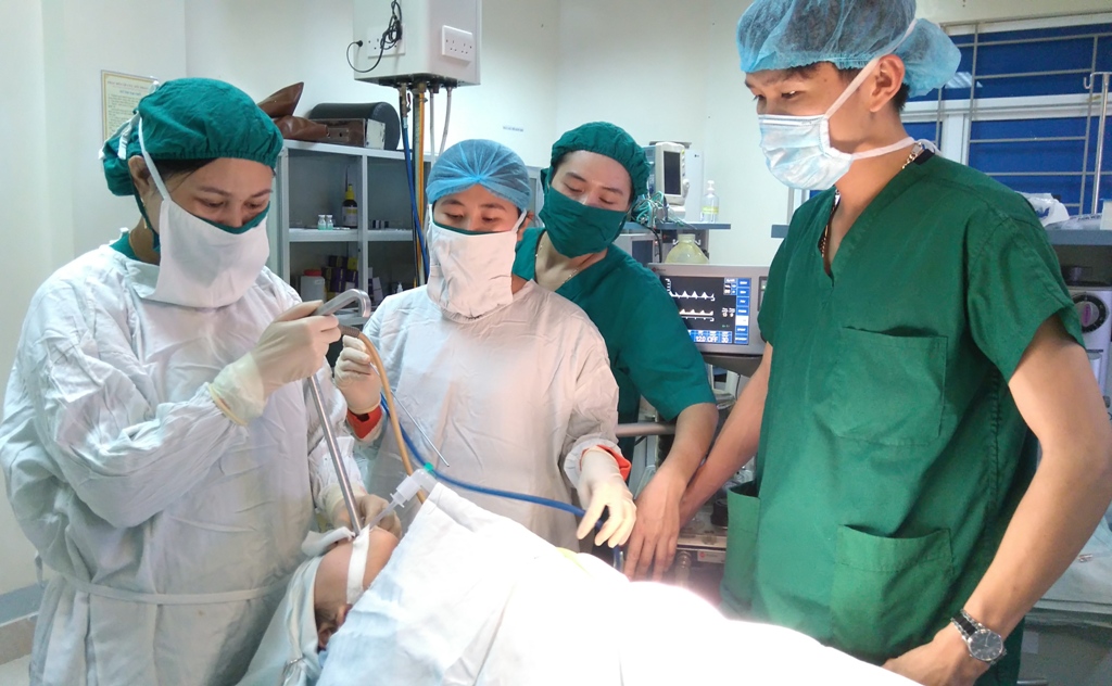 Các bác sĩ phẫu thuật gắp đồng xu trong cổ bệnh nhi Lê Thị Quỳnh Ngân - Ảnh: Nguyễn Đức