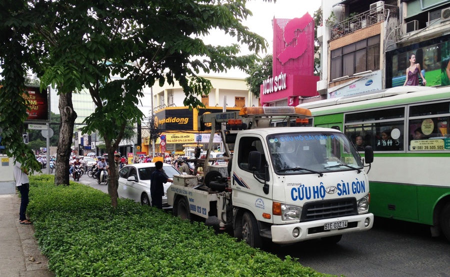 Sau gần 1 giờ "cố thủ" thì tài xế Vũ bị kéo ra ngoài và xe ô tô được đưa về trụ sở công an quận 3 - Ảnh: Đức Tiến