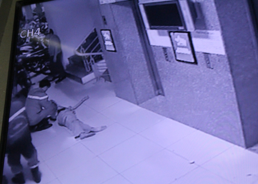Một người đàn ông lớn tuổi bị ngất xỉu được lực lượng chức năng đưa ra ngoài - Ảnh: Đức Tiến chụp lại màn hình camera