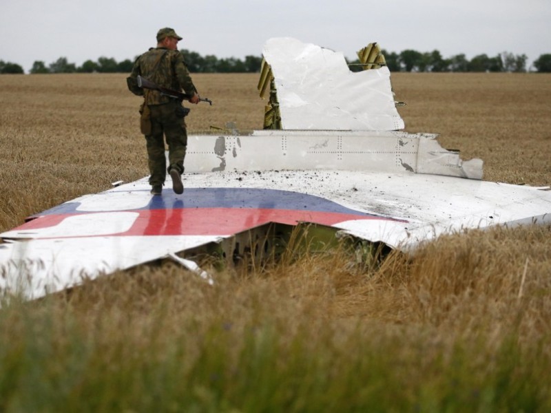 Một tay súng phe ly khai đứng trên mảnh vỡ của máy bay MH17 ở miền đông Ukraine, tháng 7.2014 - Ảnh: Reuters