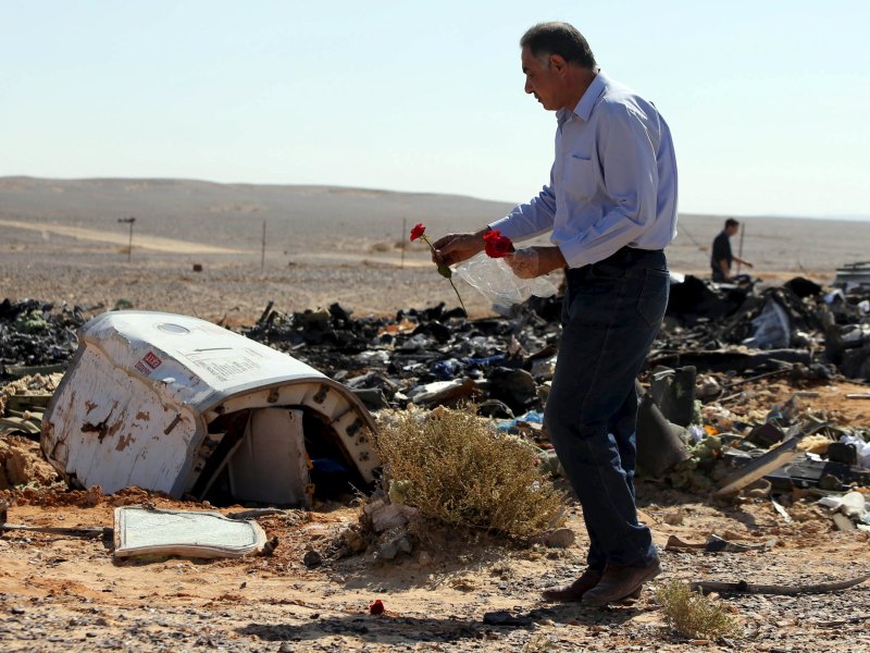 Một người đàn ông Ai Cập đặt hoa tưởng niệm tại hiện trường vụ rơi máy bay Nga ở bán đảo Sinai - Ảnh: Reuters