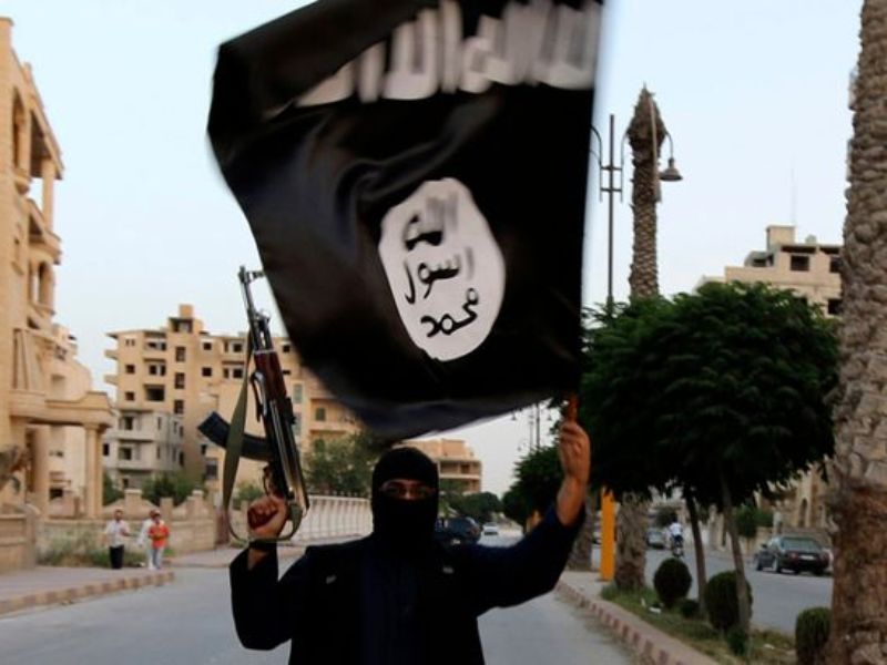 Một phần tử IS cầm cờ tổ chức này ở Syria - Ảnh: Reuters