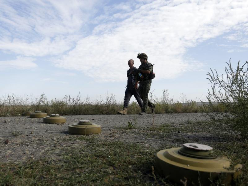Binh sĩ Ukraine đi qua một bãi mìn chống tăng ở vùng Lugansk, miền đông Ukraine - Ảnh: AFP