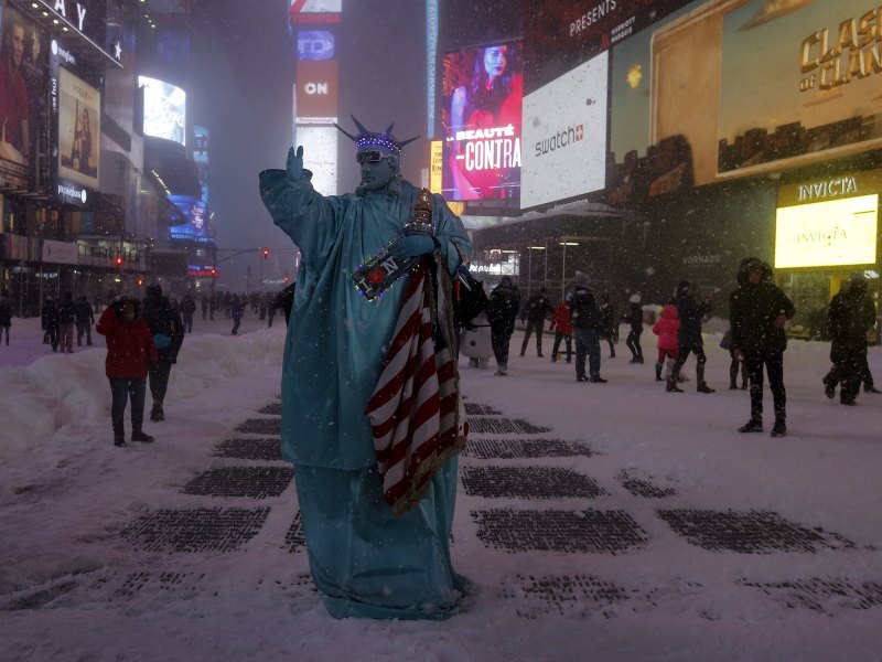 Một người đàn ông cải trang thành tượng Nữ thần Tự do trong trận bão tuyết ở quảng trường Thời Đại, New York ngày 23.1 - Ảnh: Reuters