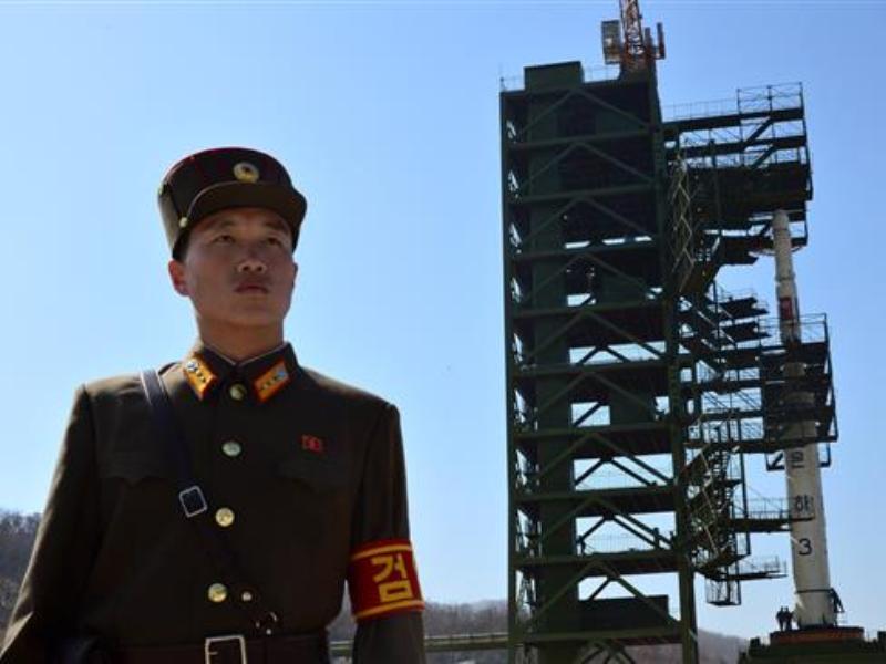Lính Triều Tiên canh gác trước tên lửa Unha-3 được dùng đưa vệ tinh lên quỹ đạo hồi năm 2012 - Ảnh tư liệu: AFP