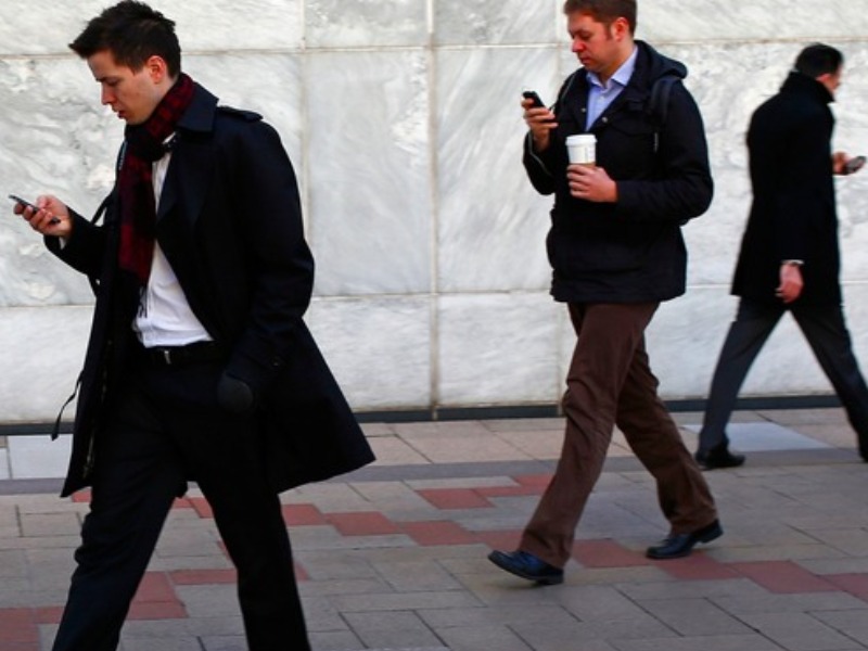 Người đi bộ dễ bị mất tập trung nếu vừa đi vừa sử dụng điện thoại - Ảnh: Reuters