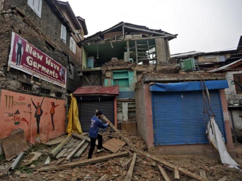 Một người dân Ấn Độ dọn dẹp đống đổ nát sau khi căn nhà ông bị sập do trận động đất 6,6 độ Richter chiều ngày 10.4.2016 - Ảnh: Reuters