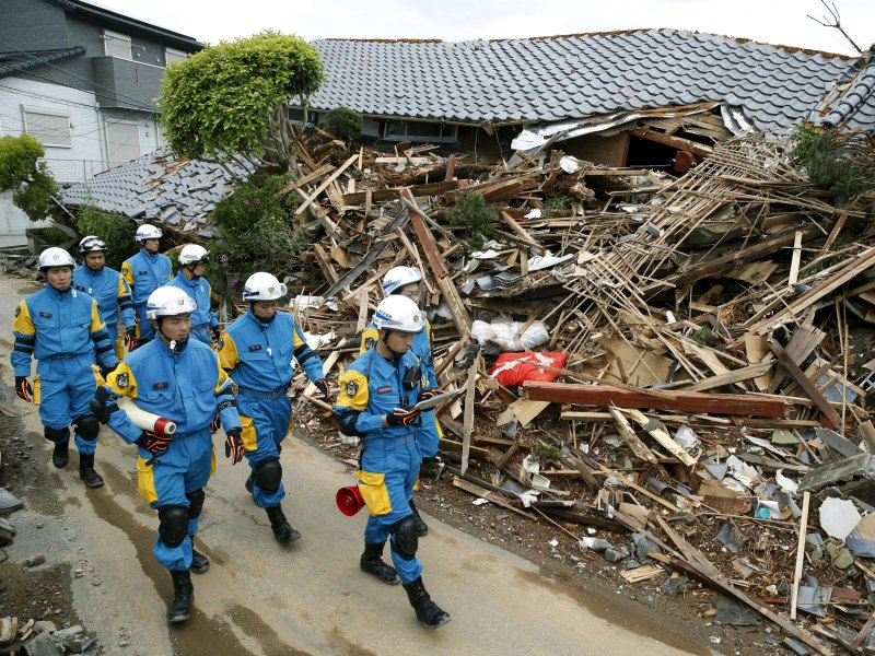 Các nhân viên cứu hộ kiểm tra một căn nhà sụp đổ sau trận đất ở thị trấn Mashiki, Nhật Bản - Ảnh: Reuters