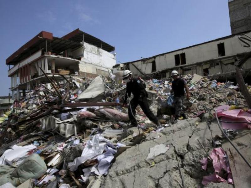 Lực lượng cứu hộ tìm kiếm nạn nhân tại một tòa nhà bị sụp đổ ở thành phố Manta - Ảnh: Reuters