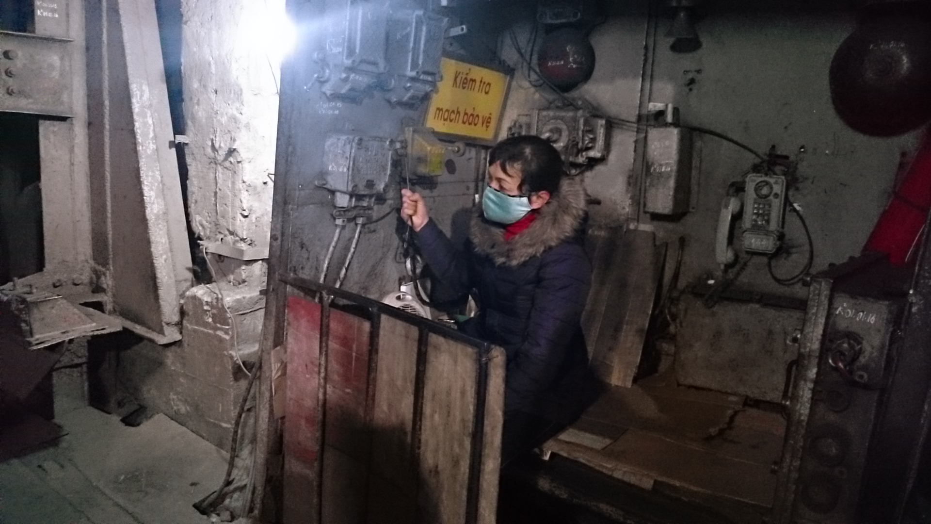 Chị Nguyễn Thị Làn, 20 năm nay vẫn ngồi tại vị trí cửa lò này để đảm bảo việc đưa công nhân lên xuống hầm lò - Ảnh: Linh Linh