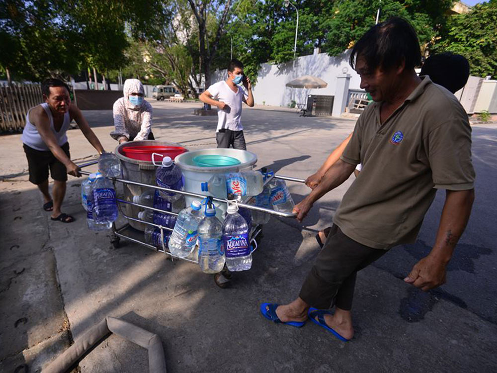 Người nhà bệnh nhân ở Khoa Lao, BV 19-8 huy động xe kéo tay để “thu gom” nước - Ảnh: Dũng Minh