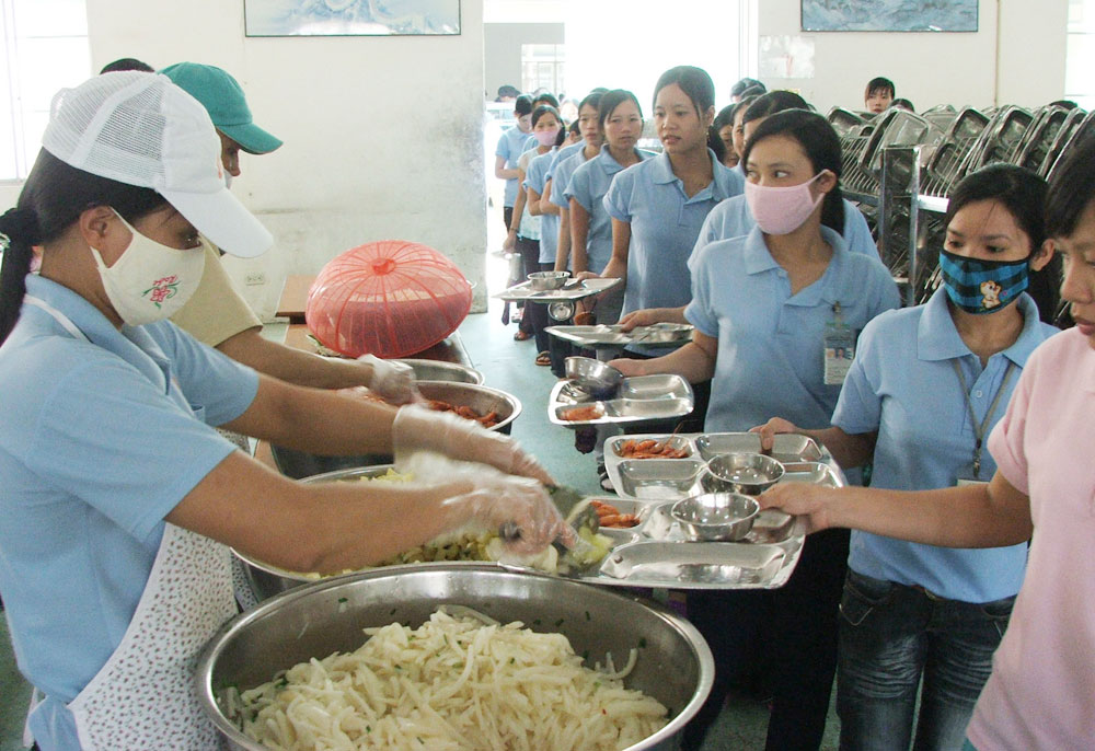 Công nhân lấy khẩu phần ăn trưa tại một công ty ở P.An Phú, TX.Thuận An, Bình Dương - Ảnh: Đỗ Trường