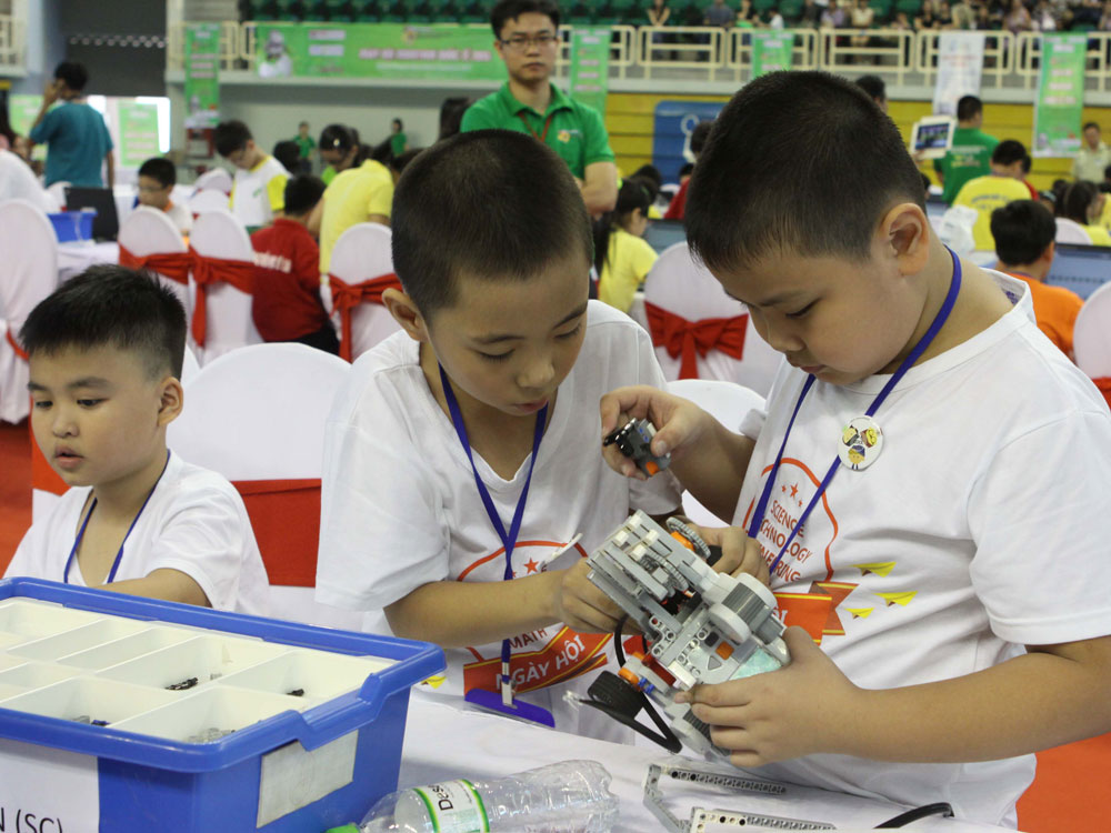 Các học sinh đội VN thi lắp ráp robot - Ảnh: TTXVN