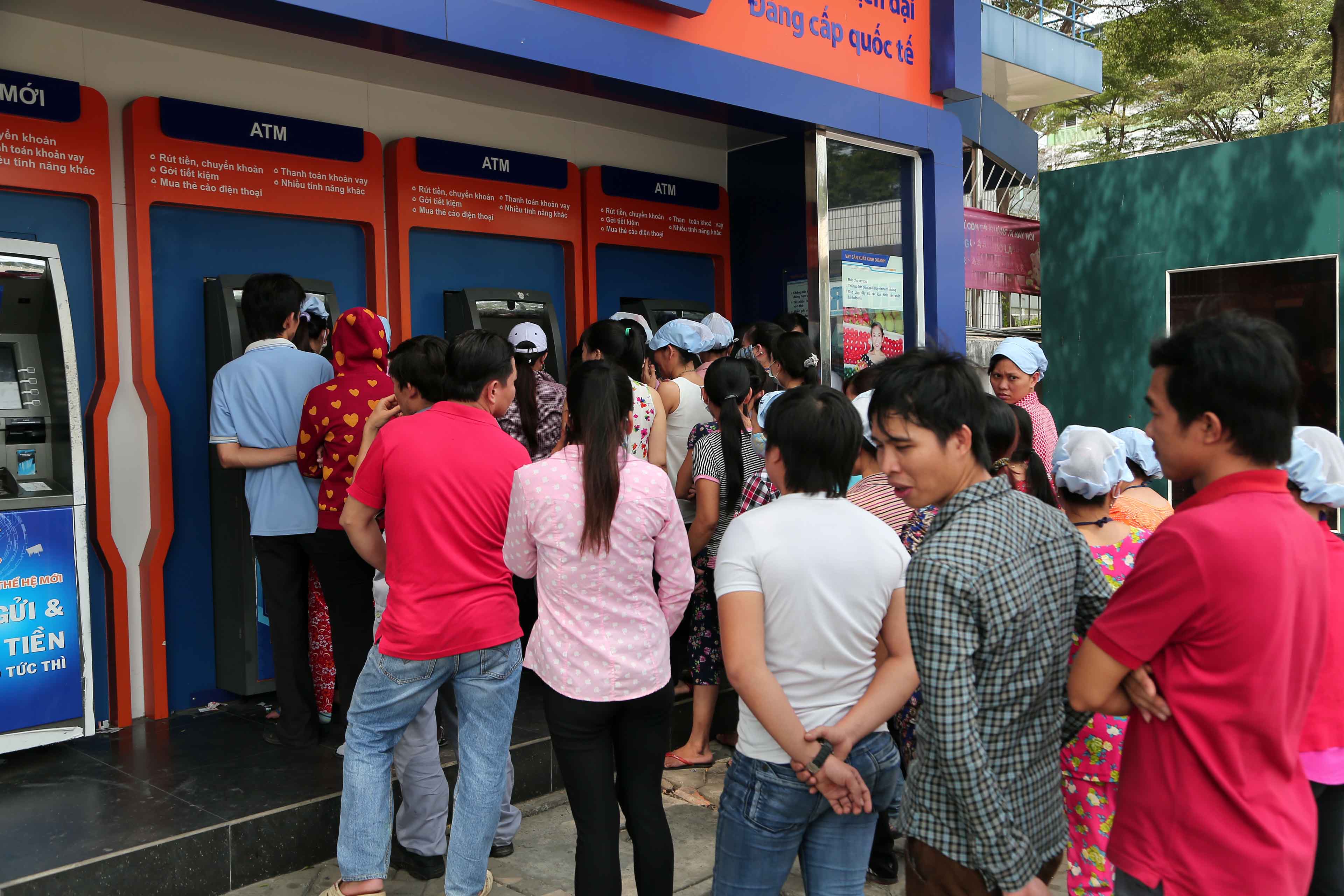 Công nhân tranh thủ rút tiền tại máy ATM, xe ATM lưu động trưa 30.1 - Ảnh: Ngọc Thạch