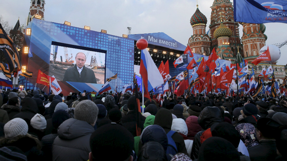 Lễ hội kỷ niệm 2 năm ngày Crimea sáp nhập vào Nga. Trên màn hình là Tổng thống Vladimir Putin đang phát biểu chào mừng sự kiện này - Ảnh: Reuters