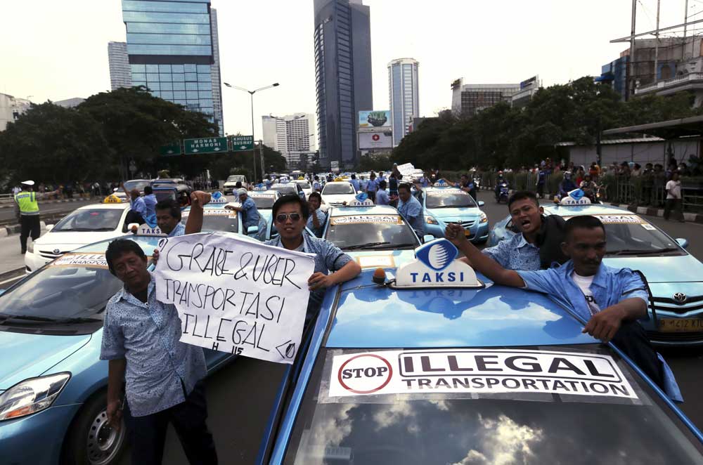Hàng ngàn tài xế taxi Indonesia biểu tình phản đối trên nhiều trục đường chính ở thủ đô Jakarta hồi tuần trước, yêu cầu chính phủ cấm cửa Uber và Grab - Ảnh: Reuters