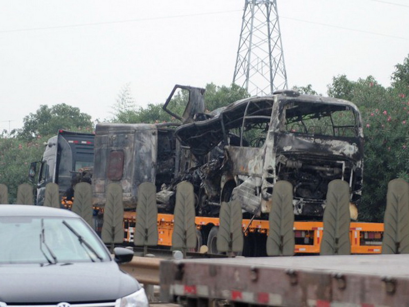 Chiếc xe buýt cháy đen sau khi tông vào một chiếc xe tải ở tỉnh Hồ Nam, khiến ít nhất 22 người chết - Ảnh: AFP 