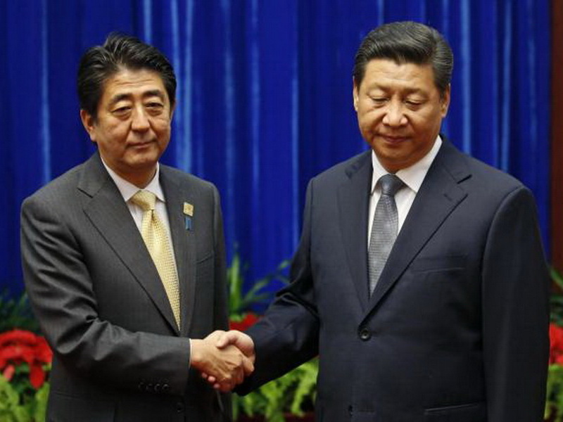 Thủ tướng Nhật Shinzo Abe (phải) bắt tay Chủ tịch Trung Quốc Tập Cận Bình khi 2 ông gặp mặt bên lề hội nghị APEC ở Bắc Kinh hồi năm 2014 - Ảnh: Reuters 