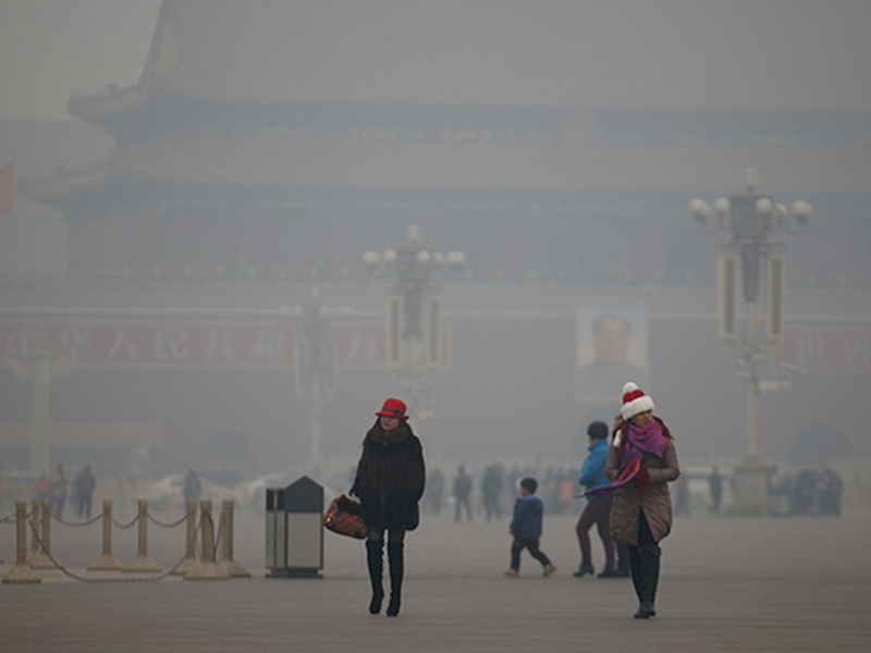 Người dân Trung Quốc dạo bước trong bầu trời mờ mịt khói mù ô nhiễm tại Quảng trường Thiên An Môn ở Bắc Kinh - Ảnh: Reuters 