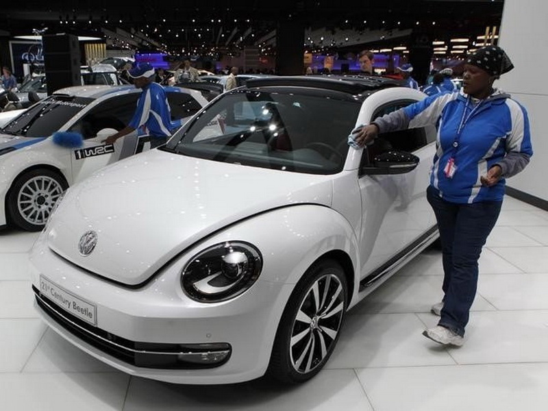 Nhân viên lau chùi một chiếc Volkswagen 21st Century Beetle tại triển lãm xe ở Nam Phi - Ảnh: Reuters