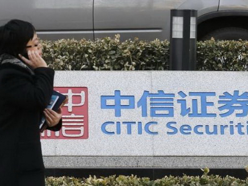 Một người phụ nữ đi ngang trụ sở Citic, công ty chứng khoán lớn nhất Trung Quốc, ở Bắc Kinh - Ảnh: Reuters