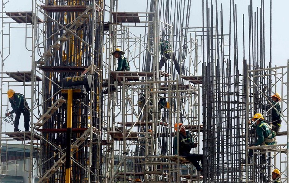 Công nhân làm việc tại một công trình xây dựng ở Hà Nội - Ảnh: Reuters
