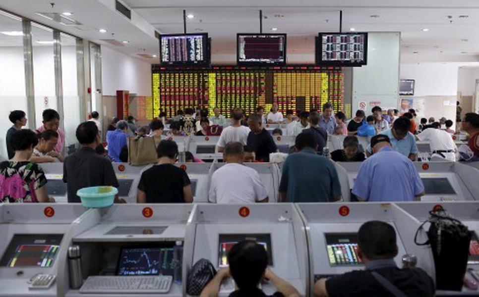 Dân chơi cổ phiếu Trung Quốc đang theo dõi giá cổ phiếu tại một công ty chứng khoán ở Thượng Hải - Ảnh: Reuters