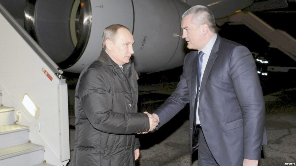 Tổng thống Vladimir Putin bắt tay thủ tướng lâm thời Crimea, ông Sergei Aksyonov tại sân bay Simferopol tối 2.12 - Ảnh: Reuters