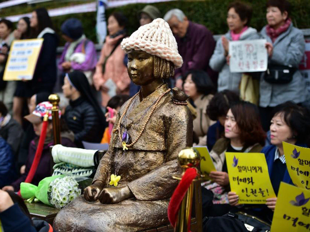 Người dân Hàn Quốc biểu tình bên tượng đài các nạn nhân bị lính Nhật ép phục vụ tình dục trong Thế chiến II, gần Đại sứ quán Nhật Bản tại Seoul ngày 11.11.2015 - Ảnh: AFP