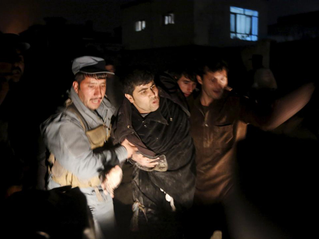 Cảnh sát đưa người bị thương khỏi hiện trường vụ đánh bom ở nhà hàng tại Kabul tối 1.1.2016 làm 1 người chết và hàng chục người bị thương - Ảnh: Reuters