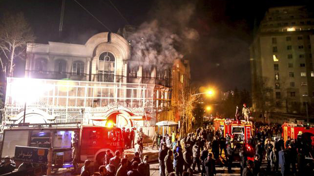 Người biểu tình Iran trước đại sứ quán Ả Rập Xê-Út ở Tehran tối 2.1, toà nhà này đầy khói vì bị ném bom xăng, cứu hoả Iran và cảnh sát phải đến can thiệp - Ảnh: Reuters